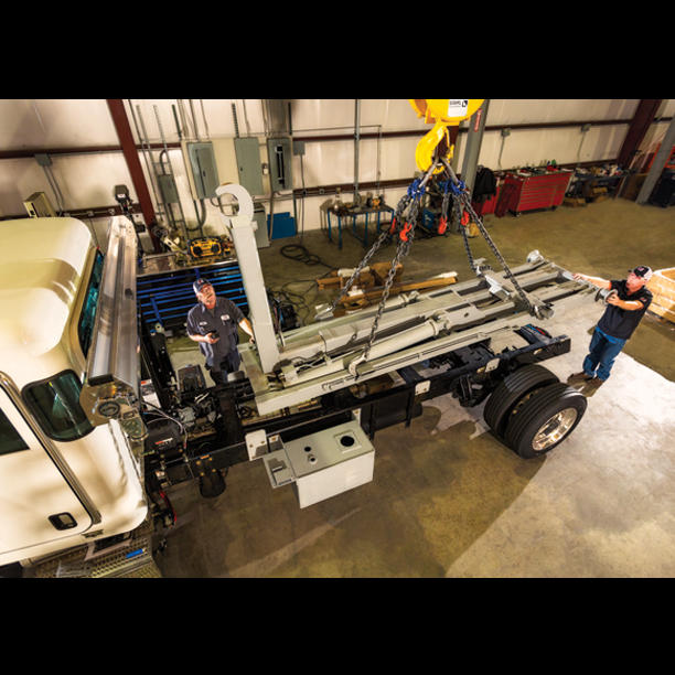 Techs installing truck body with hook lift