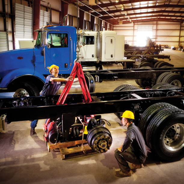 Technicians working on truck chassis