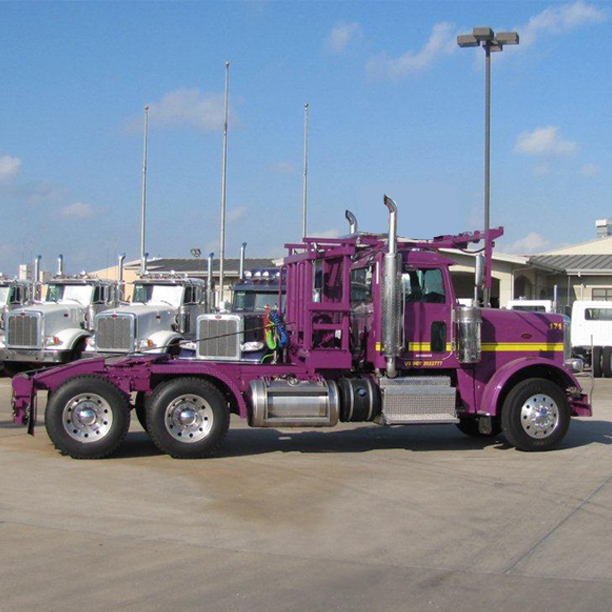 Side view of purple roll off truck