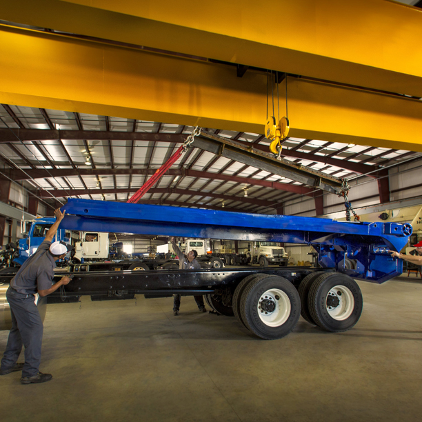 Techs installing body on truck with hook lift