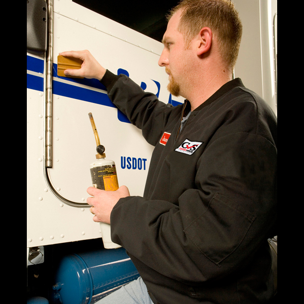 Tech applying vinyl graphics to truck door