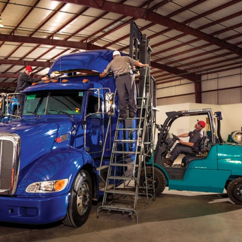 Techs working on heavy-duty truck cab