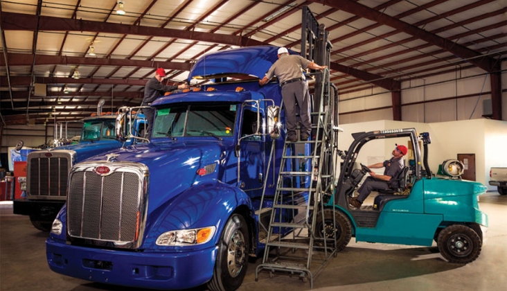 Tech working on heavy-duty truck cab