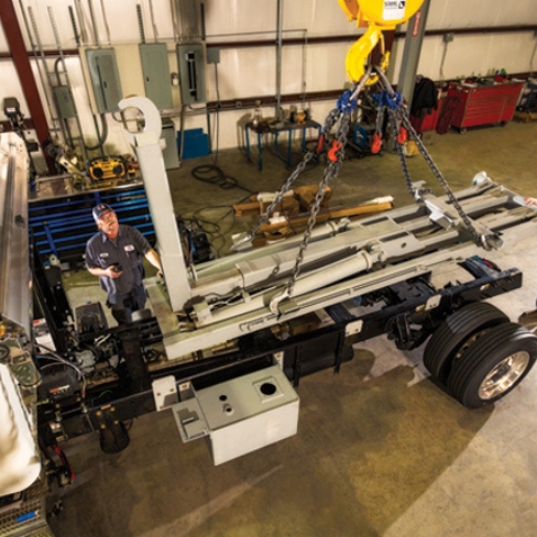 Tech installing truck body with hook lift