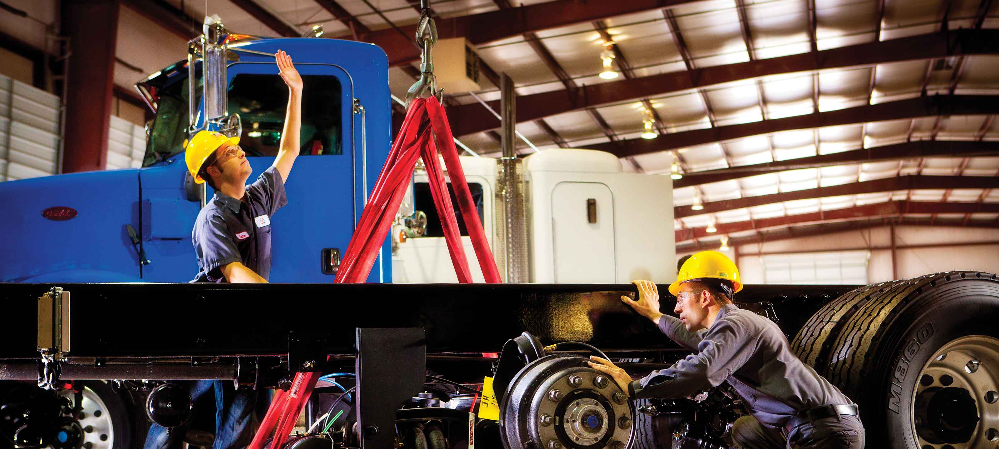 Technicians working on truck axle